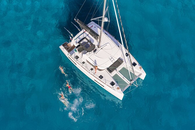 Catamaran Day & Sunset Cruises with meals Drinks and transportation - Sailing views: Mykonos coastline, windmills, and a BAOS pirates pass-by