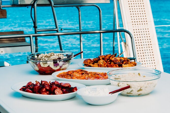 Santorini Caldera Gold Day Cruise with BBQ on board and Open Bar - Past the 19th-century lighthouse and the rocky Black Mountain
