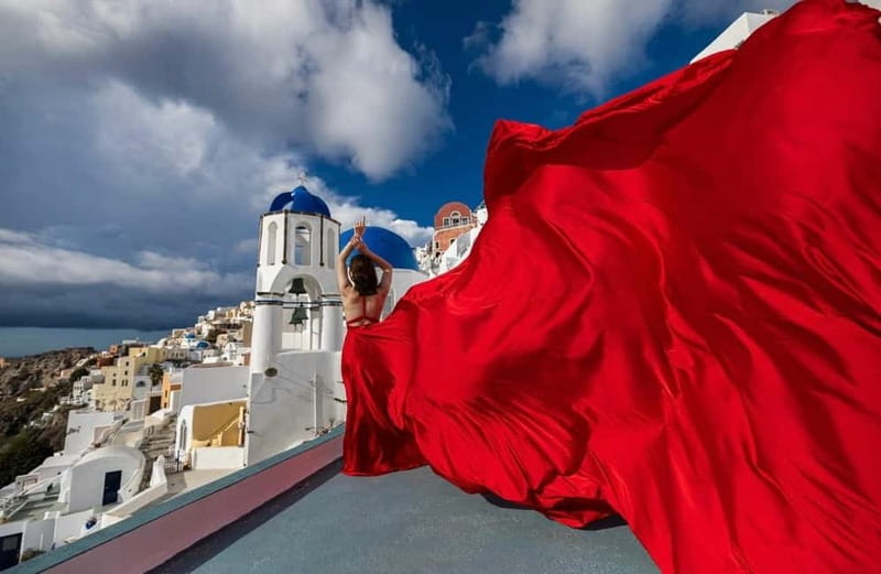 Santorini: Flying Dress Photoshoot <strong>Dress Included</strong> – Key things to know before you fly in your dress’ /></p>
<ul>
<li><strong>Dress rental is included</strong> for solo, couple, or best friends options, with one dress per lady.</li>
<li><strong>Pick your color ahead of time</strong> from a catalog emailed after booking (15 color options, sizes US 0 to 18, XS to XL).</li>
<li><strong>You get pose coaching</strong> during the shoot, so even if you hate posing, you still end up with strong, natural-looking images.</li>
<li><strong>Time choice changes the route</strong>: 1-hour keeps it in Oia, while 3-hour adds iconic blue domes plus Black Beach and an Imerovigli viewpoint.</li>
<li><strong>A staff member helps the dress fly</strong> on the day, which is key to getting that flowing, wind-swept look.</li>
<li><strong>Bring practical sun gear</strong>: water, sunscreen, and sunglasses if you’re sensitive to bright light.</li>
</ul>
<h2 id="why-the-flying-dress-effect-works-so-well-in-oia">Why the flying dress effect works so well in Oia</h2>
<p><img width="800" height="534" decoding="async" src=